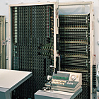 CP20形自動式構内交換装置:クロスバスイッチ(右)、リレー架(左)、交換卓の写真