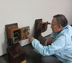 デルビル磁石式電話の説明をする中澤さんの写真